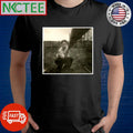 A man takes a selfie using a stick of wood to activate the camera, 1957 shirt